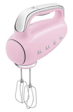 an electric hand mixer with the word smeg on it's side, in pink