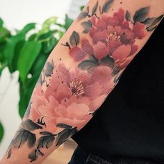 a woman's arm with flowers painted on it