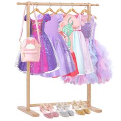 a wooden rack with several dresses and purses on it's hangers next to shoes