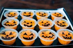 cupcakes decorated with jack - o'- lantern faces in plastic cups