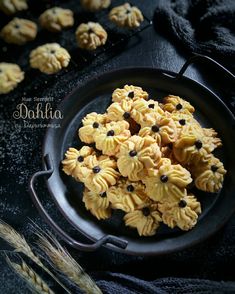 some cookies are sitting on a black plate with ears of wheat in the foreground