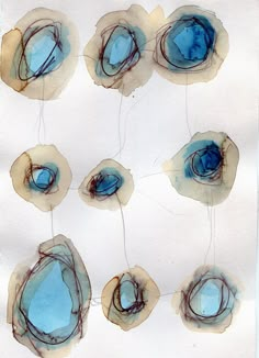 blue and brown circles on white paper with watercolors in the middle one circle