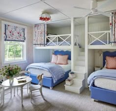 a bedroom with bunk beds and blue bedding in the corner, along with a table and chairs