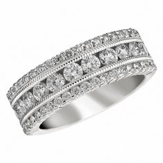 a wedding ring with rows of diamonds on the sides and an intricate band in white gold