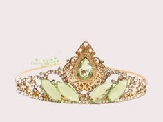 a tiara with green leaves and crystal stones on the front, in gold tone