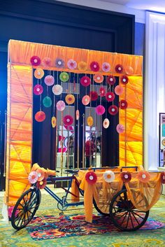 an elaborately decorated stage set up for a party with orange and pink decorations on it