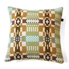 a green and brown pillow sitting on top of a white wall