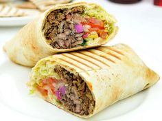 two burritos are stacked on top of each other with meat and veggies