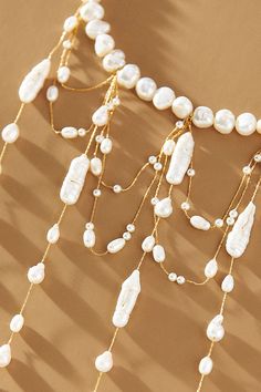 A stunning display of freshwater pearls, this choker necklace features a string of pearls that elegantly encircle the neck. Below, elongated droplets and draped strands intertwine gracefully, creating a lustrous and eye-catching statement piece. | Waterfall Pearl Choker Necklace by Anthropologie in Gold, Women's, Gold/Plated Brass/Freshwater Pearl Statement Beaded Necklace, Pearl Necklace With Dangling Beads For Party, Elegant Beaded Drop Necklace, Elegant Pearl Necklaces With Dangling Beads, Pearl Drop Necklace For Party, Luxury Pearl Choker Necklace, Elegant Beaded Pearl Necklace With Dangle, Elegant Multi-strand Necklace With Dangling Beads, Elegant Drop Necklace With Dangling Beads For Party