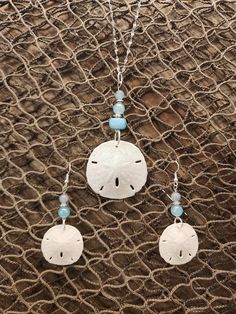 "Gorgeous natural sand dollar necklace with matching earring set. The sand dollars are real and are in their natural condition, and accented with beads in varying shades blue. This would be a gorgeous set for a beach wedding for a bride. bridesmaids, or just a gift for the beach lover in your life. The pendant (approximately 1.5\" across) is set on an 18\", anti-tarnish stainless steel chain that sparkles in the light. Multiple sizes of chain are available. The set is also available in stainless Crafts To Do With Sand Dollars, Coastal Diy, Beach Crafts Diy, Sand Dollar Earrings, Sand Dollar Necklace, Aventurine Jewelry, Pendant And Earring Set, Beach Shells, Beachy Jewelry