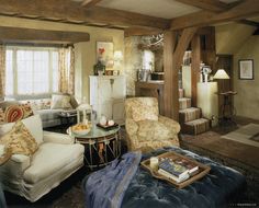 a living room with couches, chairs and a table in front of a window