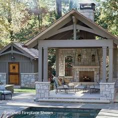 an outdoor fireplace and patio area next to a swimming pool