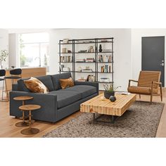 a living room filled with furniture and bookshelves next to a wooden coffee table