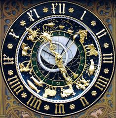 an ornate clock with roman numerals and zodiac signs on it's face