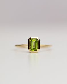 The octagon-shaped peridot on this ring is both eye-catching and elegantly simplistic. It is the perfect way to celebrate a special August birthday or simply adorn oneself with its stunning light green hue. Unique Peridot Ring, Peridot Ring Design, Green Peridot Ring, August Birth Stone Ring, Stackable Emerald Cut Green Birthstone Ring, Green Emerald Cut Stackable Birthstone Ring, Green Emerald-cut Stackable Birthstone Ring, Formal Peridot Birthstone Ring For May, Stackable Peridot Birthstone Ring For Anniversary