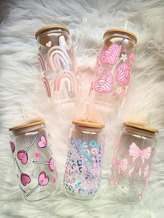 four glass jars with hearts and rainbows painted on them