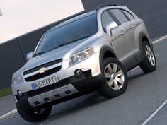 a silver chevrolet suv is driving down the road