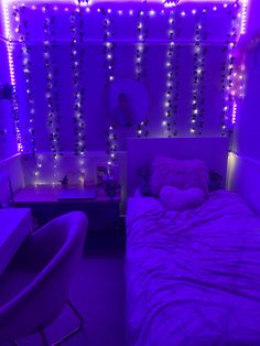 a bedroom with purple lights on the wall and a bed in front of a desk