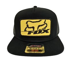 the fox trucker hat in black and yellow with an embroidered patch on the front