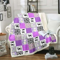 a living room with a white couch and purple quilt