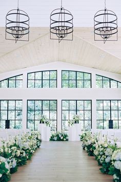 Elegant indoor wedding ceremony featuring stunning white and blue floral arrangements lining the aisle, set in a bright, airy venue Minimalist Indoor Wedding, Wedding Ceremony Platform, Ceremony Aisle Decor Outdoor, White And Blue Floral Arrangements, Aisle Decor Outdoor, Floral Aisle Markers, Aisle Wedding Decor, Wedding Ceremony Aisle Flowers, Flower Wedding Ceremony