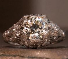 an antique diamond ring sitting on top of a rock