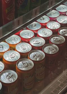 many cans of soda are lined up on the shelf