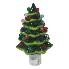 a green glass christmas tree night light with multi colored lights on it's base