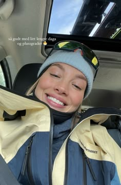 a woman sitting in the back seat of a car with her eyes closed and smiling