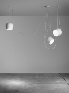 an empty room with three lamps hanging from the ceiling