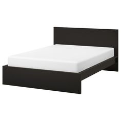 a black bed frame with white sheets on it