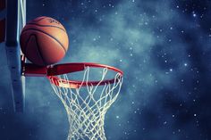 a basketball is going through the hoop in front of stars and clouds on a night sky