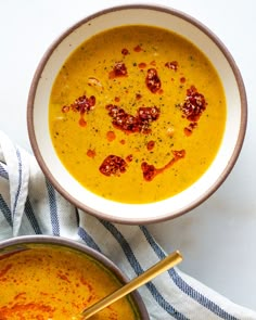 two bowls filled with soup on top of a table