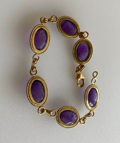 "This is lovely retro 14k Amethyst Cabochon Bracelet Very nice sized luscious purple gems - clean simple design. 14k Solid Yellow Gold Hallmarked 14k, Clara Six amethyst cabochons 4 ct ea Total-of 24 cttw Measures 7.25\" L x 7mm W Excellent condition" Formal Purple Cabochon Gemstones, Elegant Cabochon Amethyst Gemstones, Elegant Amethyst Cabochon Gemstones, Formal Purple Oval Cabochon Jewelry, Elegant Purple Cabochon Jewelry, Vintage Amethyst Jewelry With Polished Finish, Formal Amethyst Jewelry, Oval Cabochon, Formal Amethyst Round Bracelets, Formal Round Amethyst Bracelets