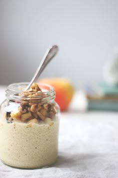 a jar filled with oatmeal and nuts on top of a white table