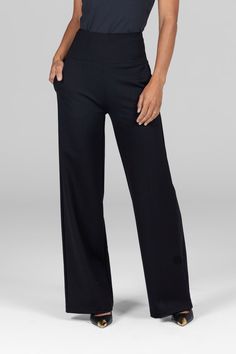 A woman is standing with one hand in her pocket, wearing black high-waist, wide-leg ponte pants. The waistband is thick and structured, emphasizing the high-rise fit, while the wide-leg design offers a loose, comfortable silhouette. The fabric appears soft and slightly stretchy. Curated Outfit, Check Mark, High Waisted Wide Leg Pants, High Waist Wide Leg Pants, Tall Pants, Petite Pants, Wide Leg Pant, 4 Way Stretch Fabric, Leg Design