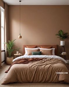 a large bed sitting under a window next to a plant in a room with brown walls