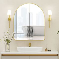 a bathroom sink sitting under a mirror next to a vase with flowers and plants in it