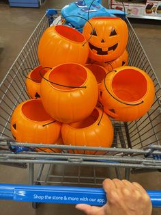 a shopping cart filled with orange pumpkins on display in a grocery store for halloween