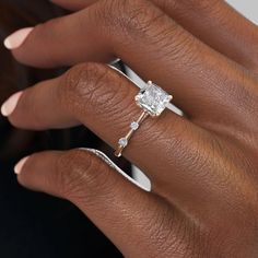 a woman's hand with a diamond ring on her finger and an engagement band