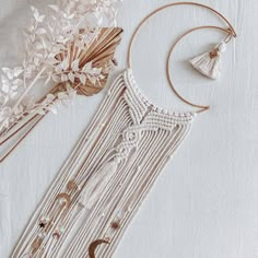 a white dream catcher next to some dried flowers