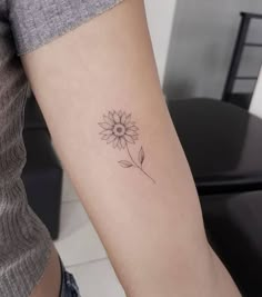 a small sunflower tattoo on the arm