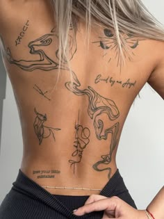 the back of a woman's body with tattoos on her upper and lower back