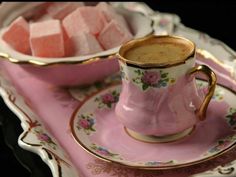 pink sugar cubes are in a bowl and on a saucer next to a plate