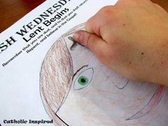 a child's hand holding a pencil over a drawing