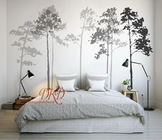 a bedroom with white walls and black trees on the wall