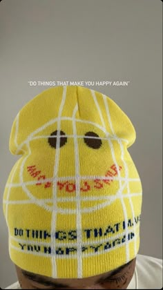 a man wearing a yellow hat with the words do things that make you happy again