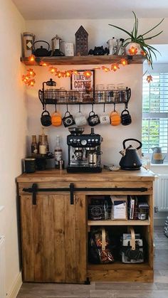 a small coffee bar in the corner of a room with shelves and lights above it