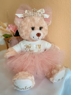 a teddy bear wearing a pink tutu and tiara