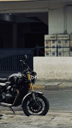 a motorcycle is parked on the side of the road in front of an apartment building